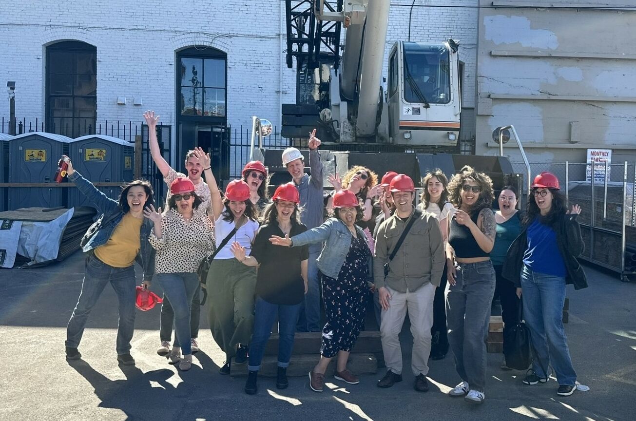 a group of people posing in construction hats